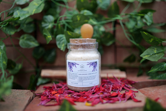 house of dandylion sugar scrub on display in a glass jar with a wooden spoon