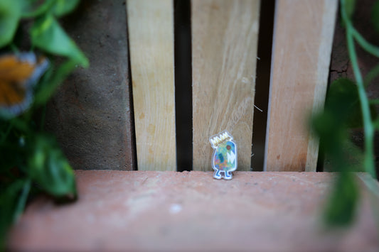 acrylic trump impeached pin laying against a wooden background with ivy 