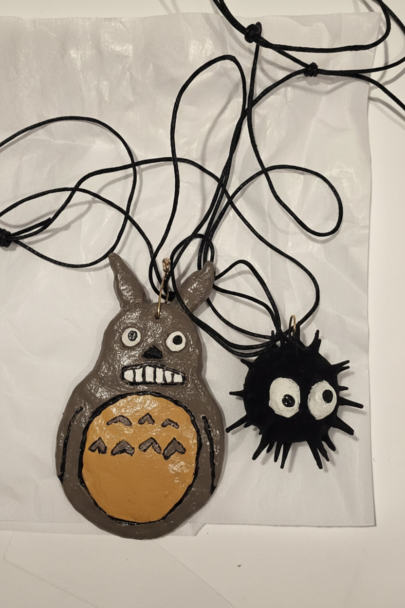 soot sprite and totoro laying on white background