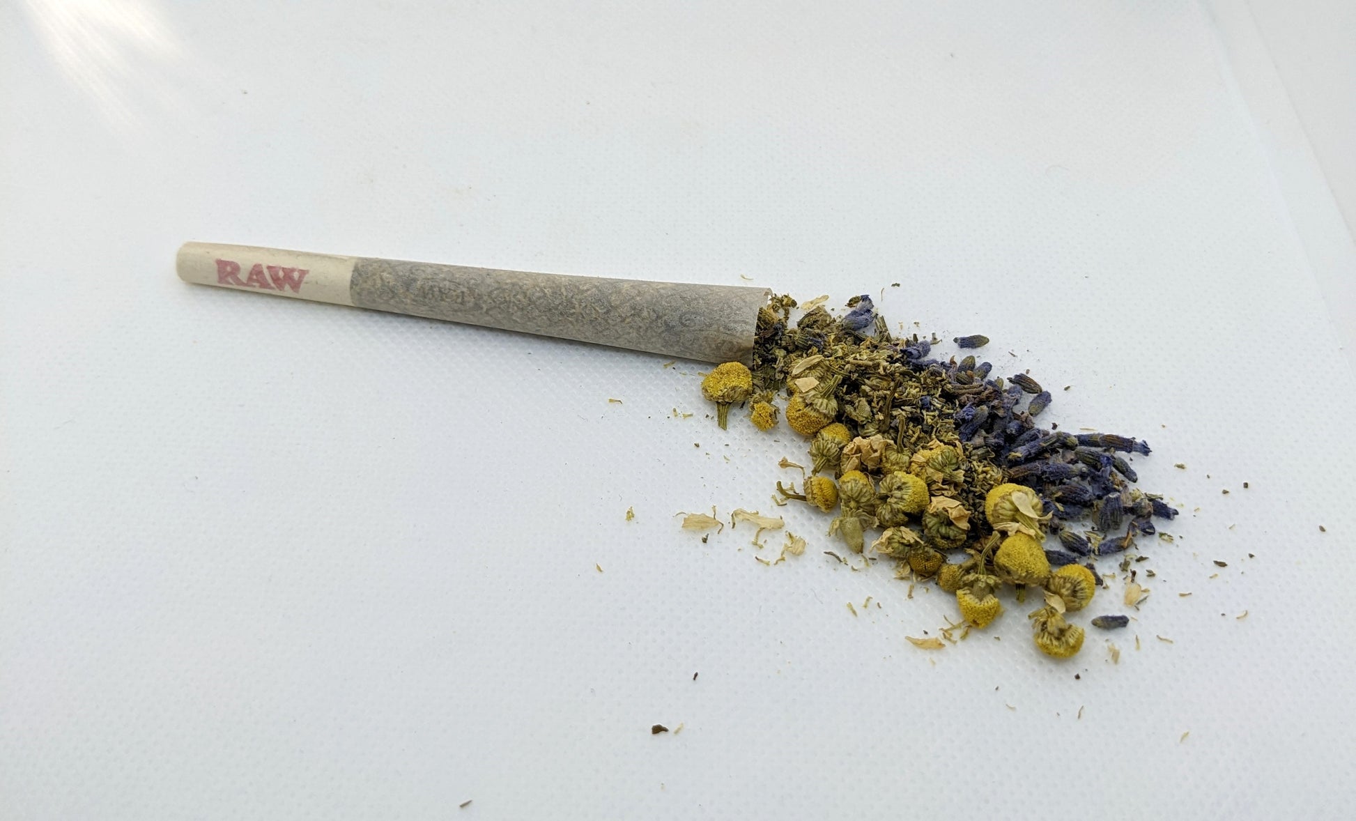 pre-roll cone with chamomile, lavender, damiana, mint, and cbd hemp flower spilling out